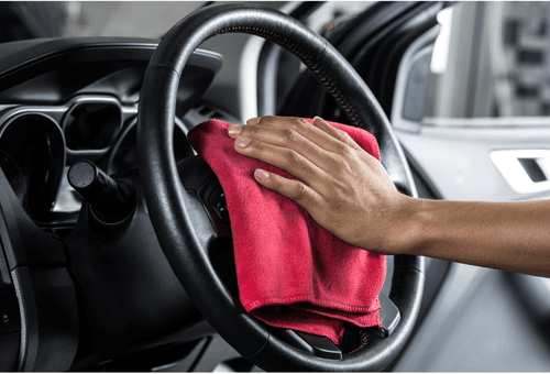 Professional car interior cleaning and detailing service showing steering wheel cleaning
